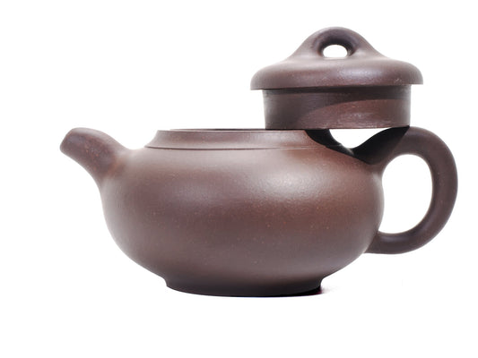 Side profile of the bronze‑grade Yun Tong Hu teapot with the lid removed and resting on the handle, highlighting the wide mouth and ring‑shaped knob.