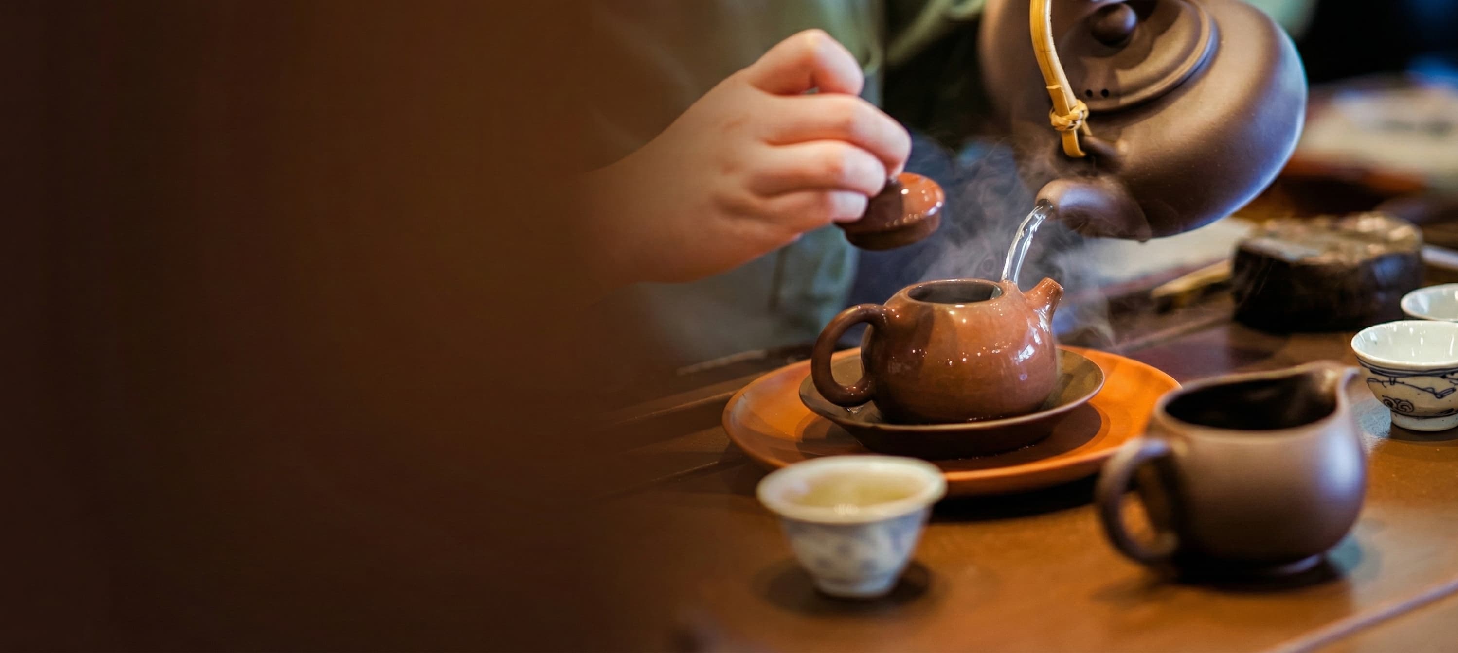 Traditional Yixing purple clay teapot pouring steaming tea during a Gongfu tea ceremony, celebrating Cha Zhi Ji's 30th Anniversary and 12.12 Sale.