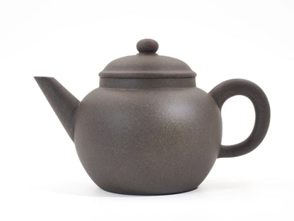 Side profile of the Gold Grade Mo Yuan Zhai teapot, displaying its warm, balanced Zisha clay tone and classic round shape.